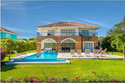 Luxury home with Chicago bricks wall veneer and coral stone pool deck around a swimming pool