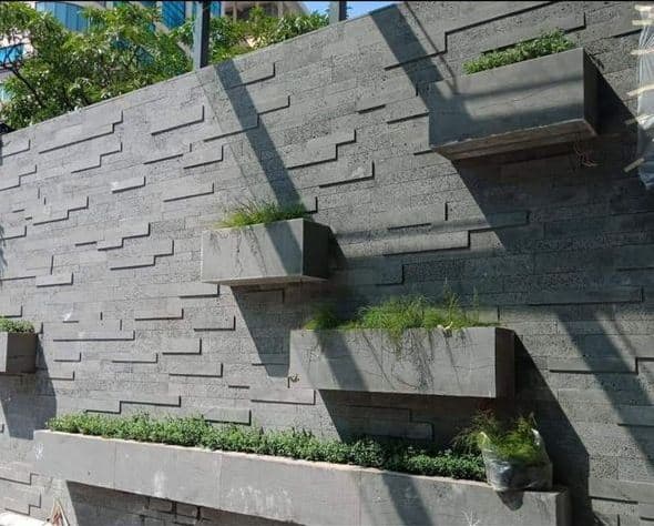 Basalt stone veneer also known as volcanic stone installed on modern exterior wall in Florida – durable dark natural stone cladding