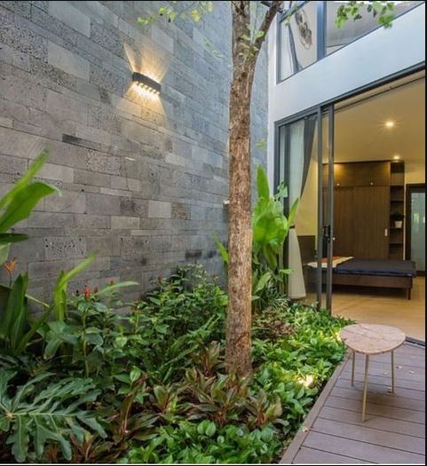 Modern facade wall with volcanic stone veneer cladding in charcoal basalt tones